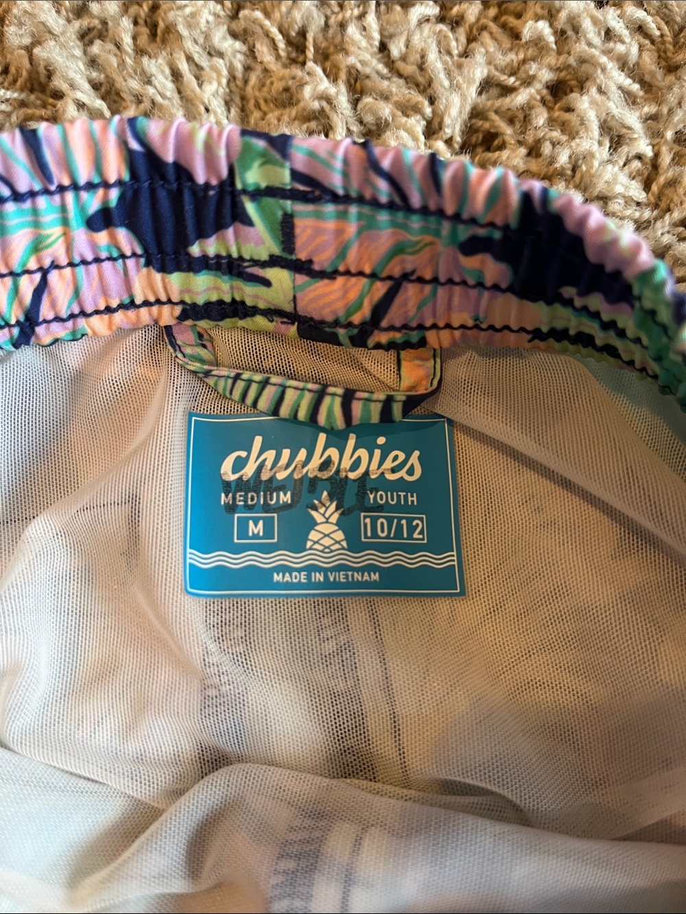Chubbies youth medium swim trunks with a navy blue base floral print. - Picture 3 of 3